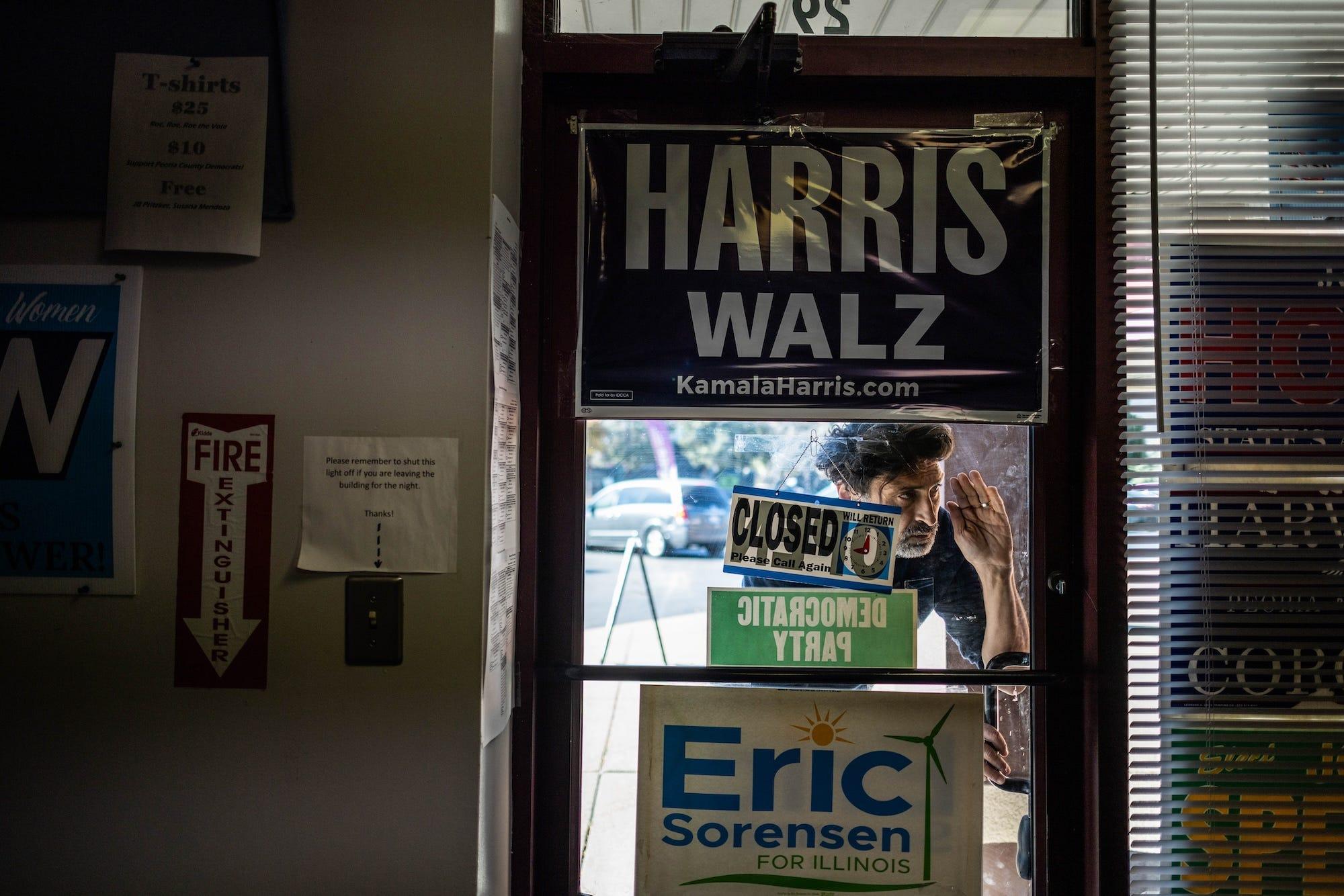 une porte présente divers panneaux de campagne, dont un pour Kamala Harris et un autre pour Eric Sorensen