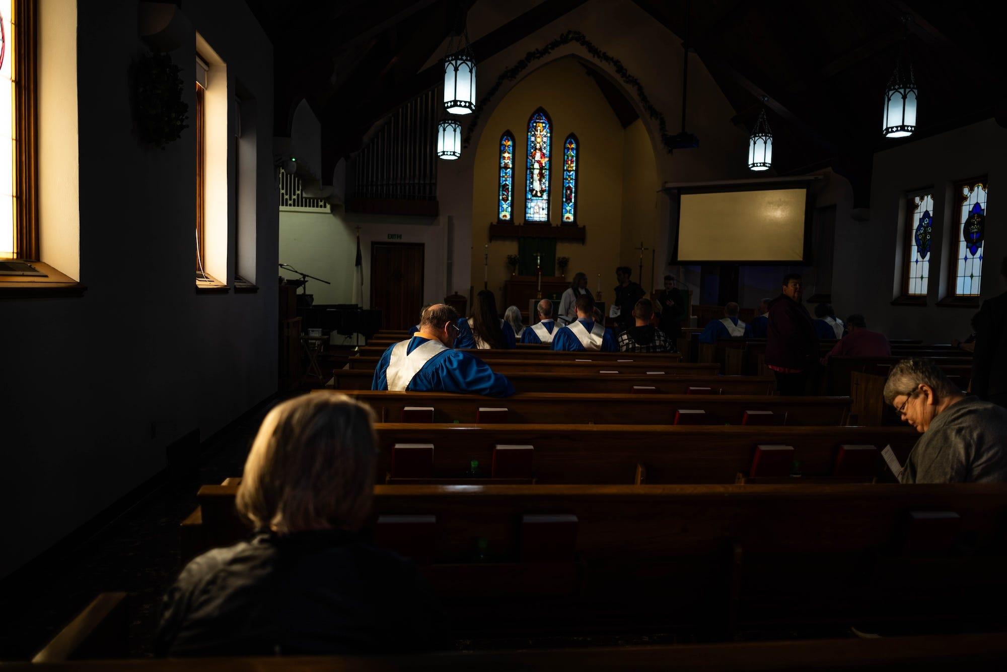 l'intérieur d'une église caractérisé par des bancs en bois disposés en rangées