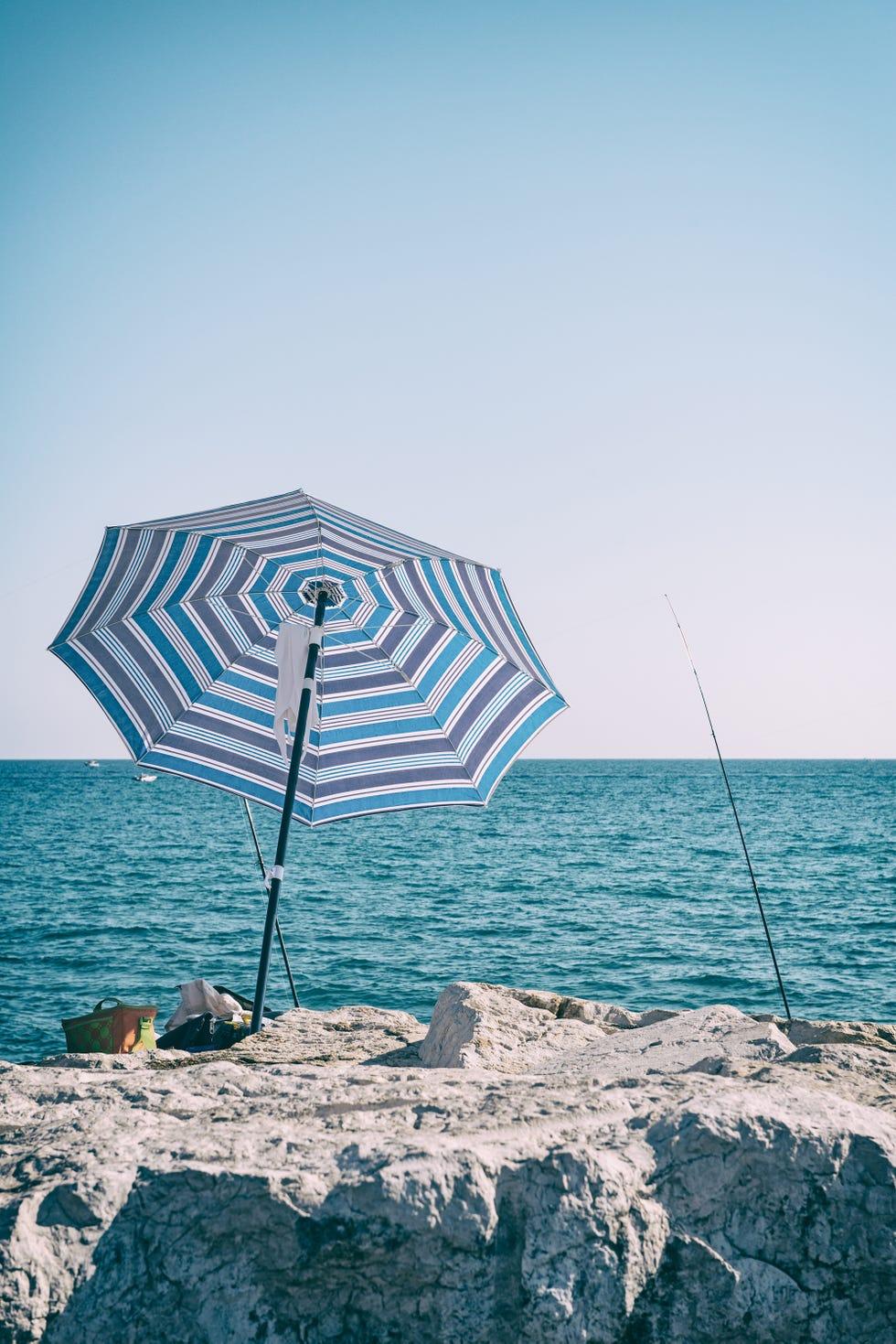 Parasol de plage et canne à pêche sur une falaise