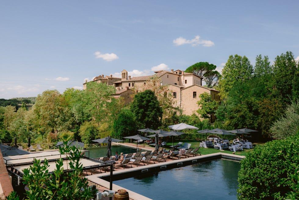 un bâtiment avec une piscine et des arbres autour