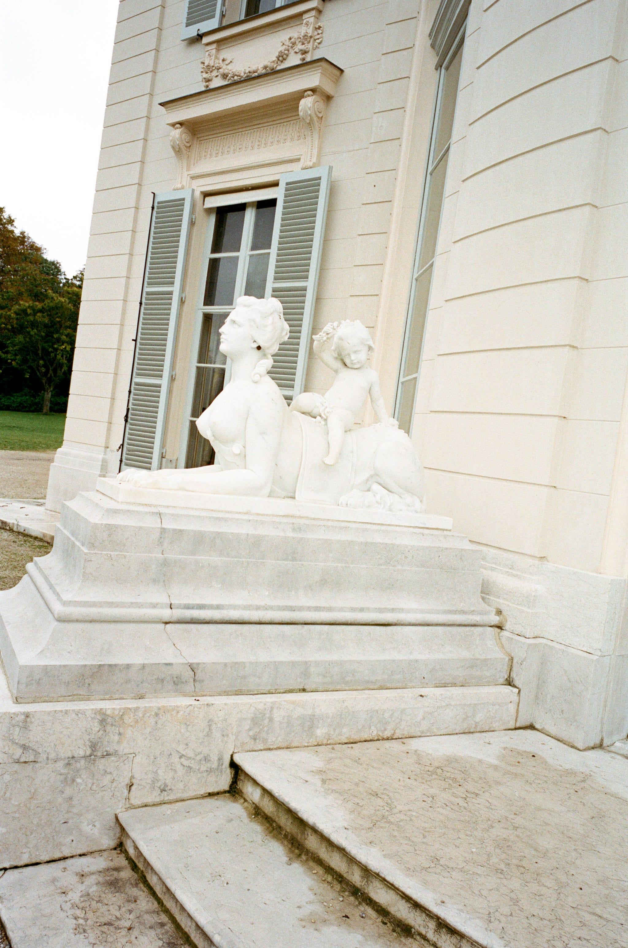 un groupe de statues blanches sur un bâtiment en pierre