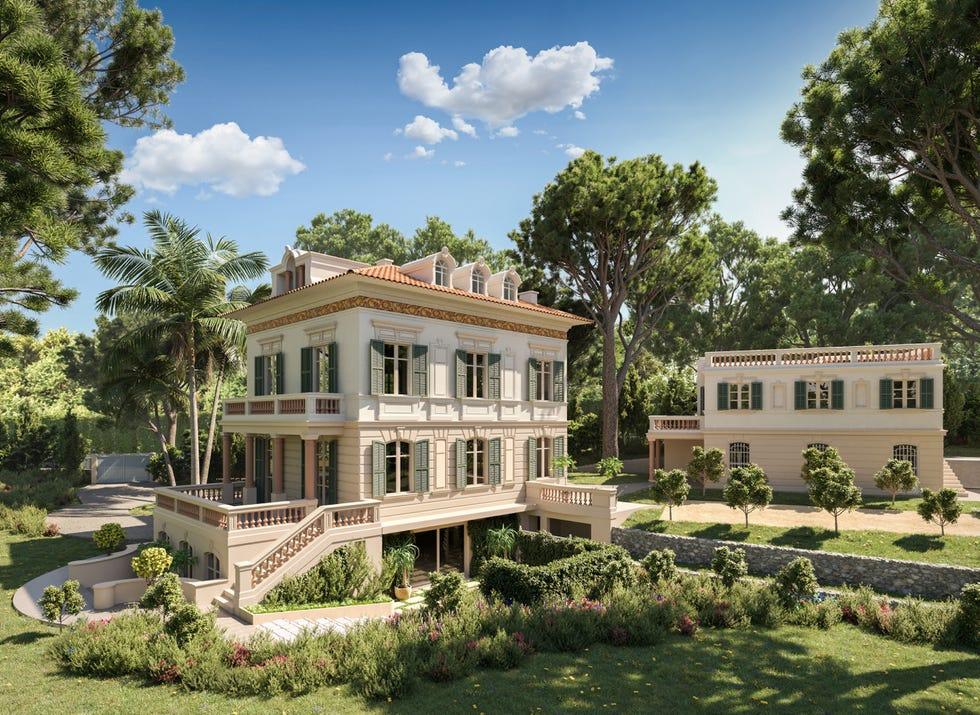 une grande maison blanche avec des arbres et des buissons autour