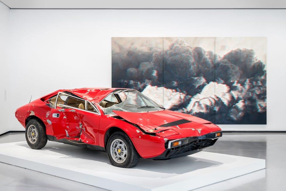 une voiture rouge devant une grande image