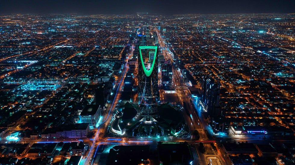 une vue aérienne spectaculaire de riyad de nuit, avec la tour du royaume illuminée au centre