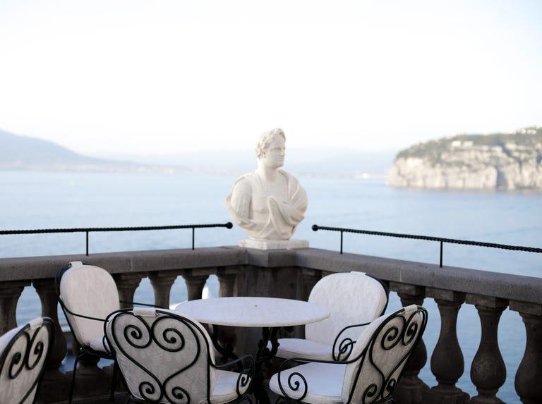 espace de restauration extérieur surplombant la mer avec une statue