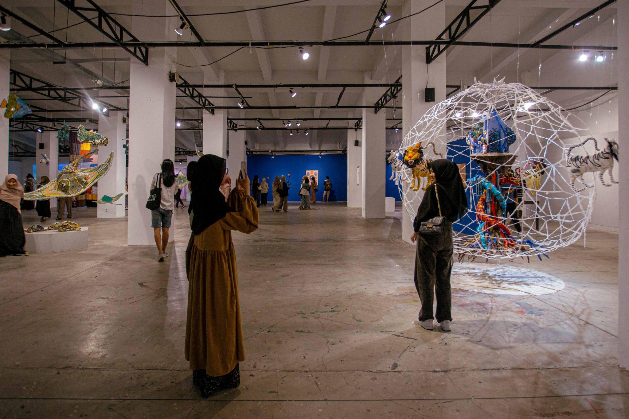 un groupe de personnes dans une pièce avec une grande exposition de cerfs-volants