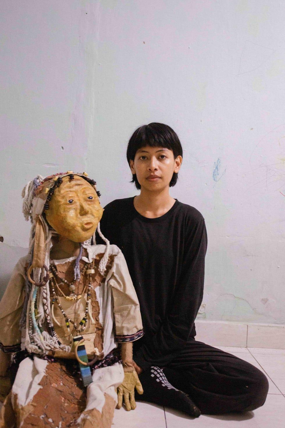 un homme assis à côté d'une statue