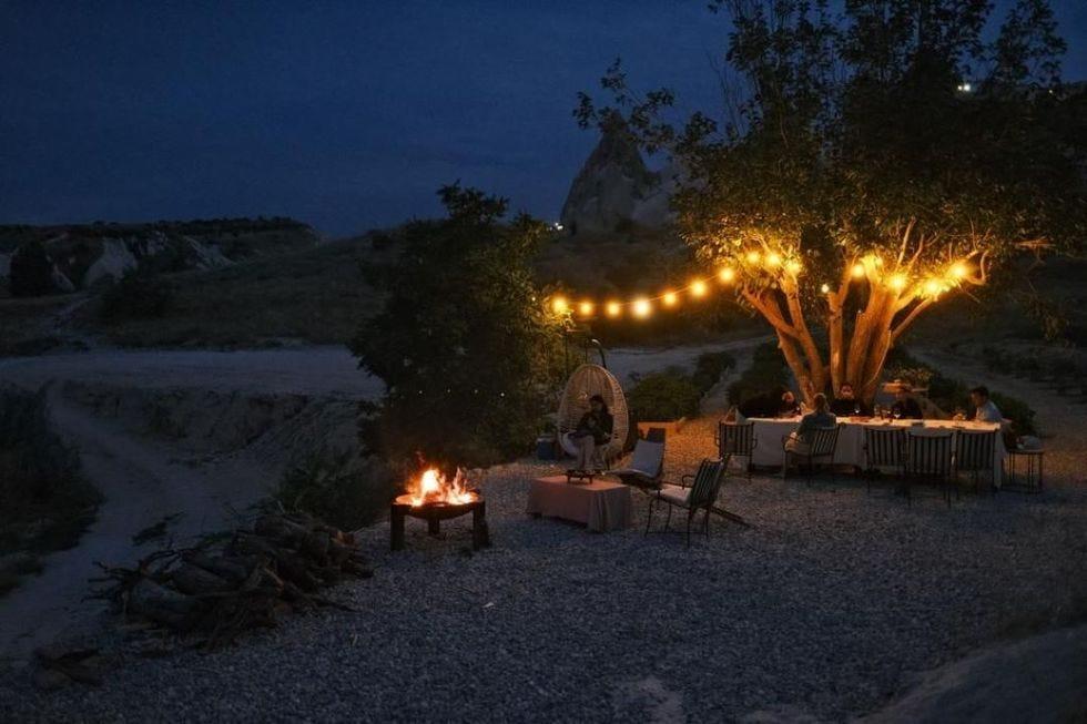 un foyer avec une table et des chaises et un arbre avec des lumières