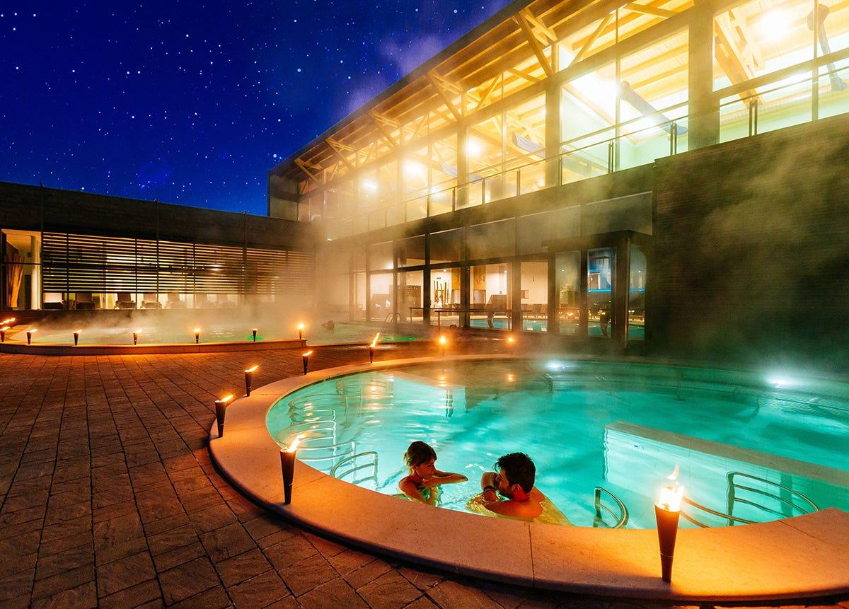 a couple of people in a swimming pool at night