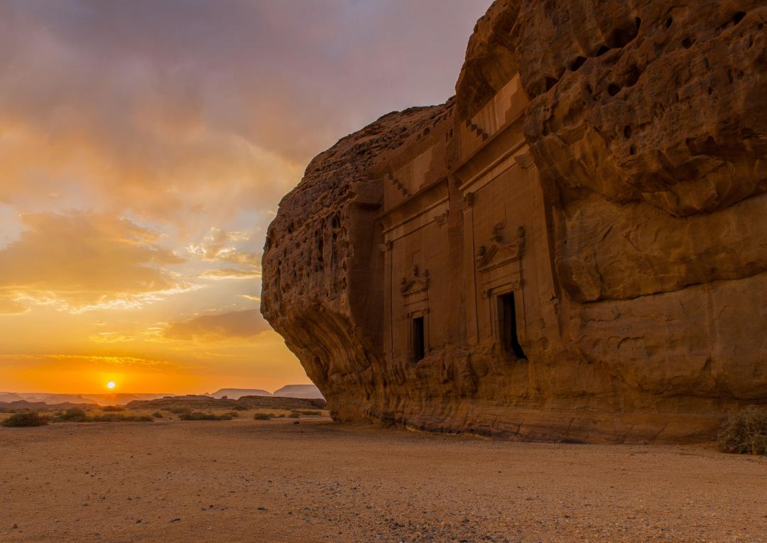 tombes anciennes taillées dans la roche au coucher du soleil dans un paysage désertique